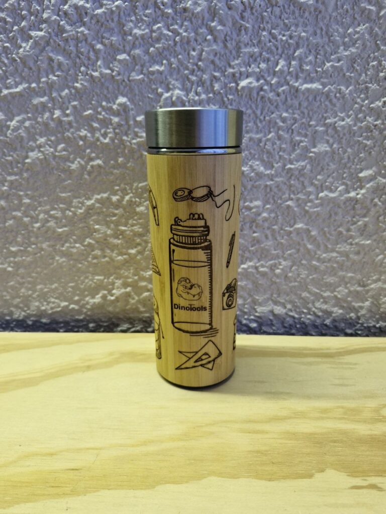 Fotografía de termo Ciencias de la Tierra. Precio: $600 MXN Marca: Dino Tools Dimensiones: Ancho 7 cm., Alto 20.6 cm. Capacidad: 500 ml. Color: Madera clara Materiales: Acero SUS 304, bambú y plástico Categoría: Nuevo