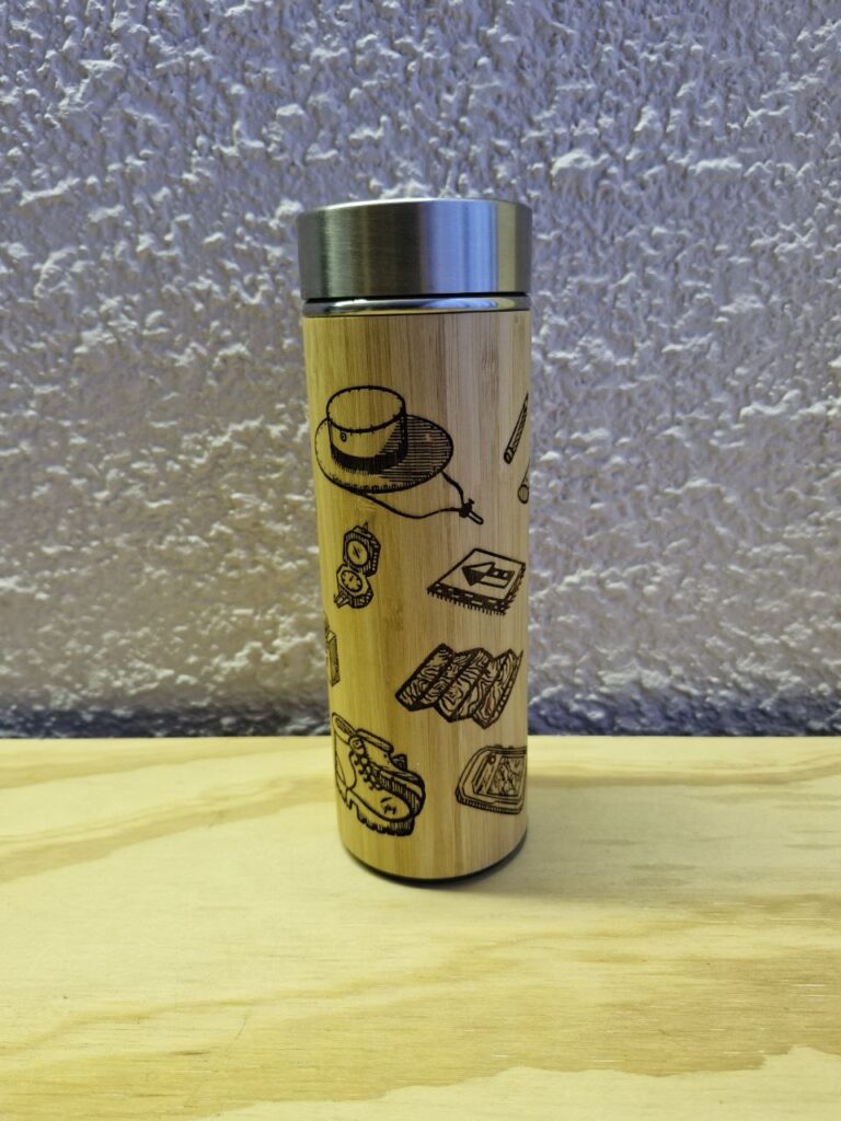 Fotografía de termo Ciencias de la Tierra. Precio: $600 MXN Marca: Dino Tools Dimensiones: Ancho 7 cm., Alto 20.6 cm. Capacidad: 500 ml. Color: Madera clara Materiales: Acero SUS 304, bambú y plástico Categoría: Nuevo