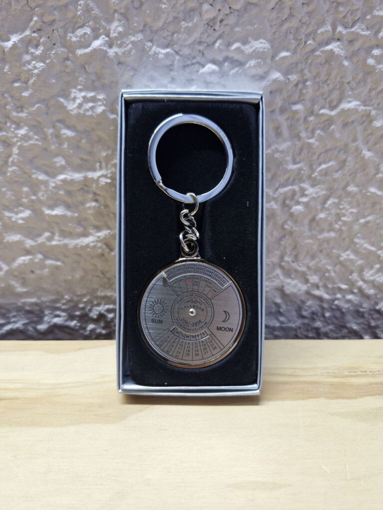 Fotografía de llavero Calendario Semiperpetuo en su estuche. Precio: $110 MXN Marca: By Alba Dimensiones: Dije: Diámetro 4.3 cm. x Grueso 0.4 cm.; Arillo: Ancho 2.5 mm. y Diámetro 3.5 cm. Material: Metal. Color: Plateado. Categoría: Nuevo.