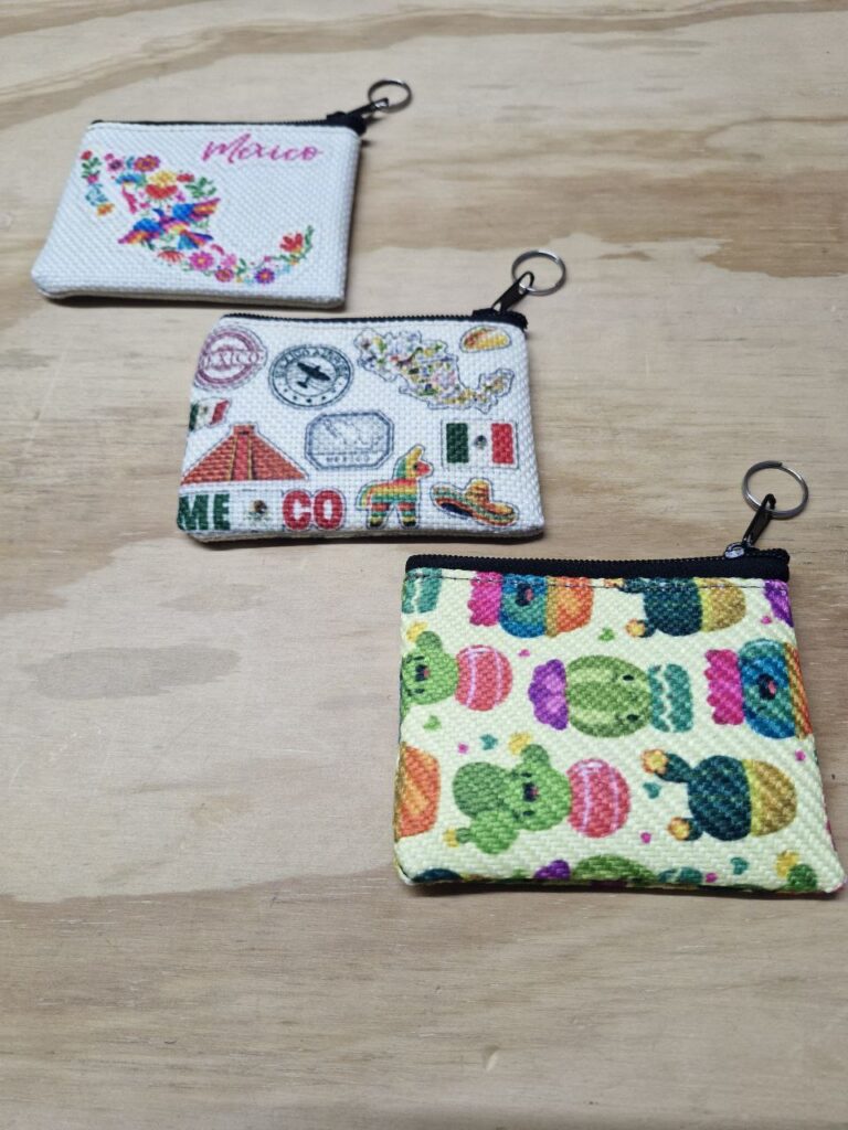 Fotografía de frente de monederos México Floral, México Sellos y Cactus. Precio de cada uno: $20 MXN Dimensiones: 11 x 9 centímetros Material: Yute plástico Color de base: Blanco Tipo de cierre: Plástico con carrito metálico Forro: Negro Categoría: Nuevo