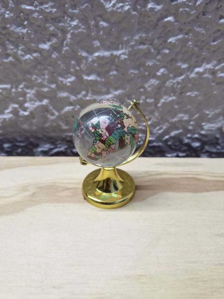 Fotografía de mini globo terráqueo modelo color. Precio: $40 MXN cada uno Diámetro: 4 centímetros Altura total: 6.4 centímetros Color: Cuerpo de globo: Transparente, Base: Dorado Materiales: Plástico, metal y cristal Categoría: Nuevo